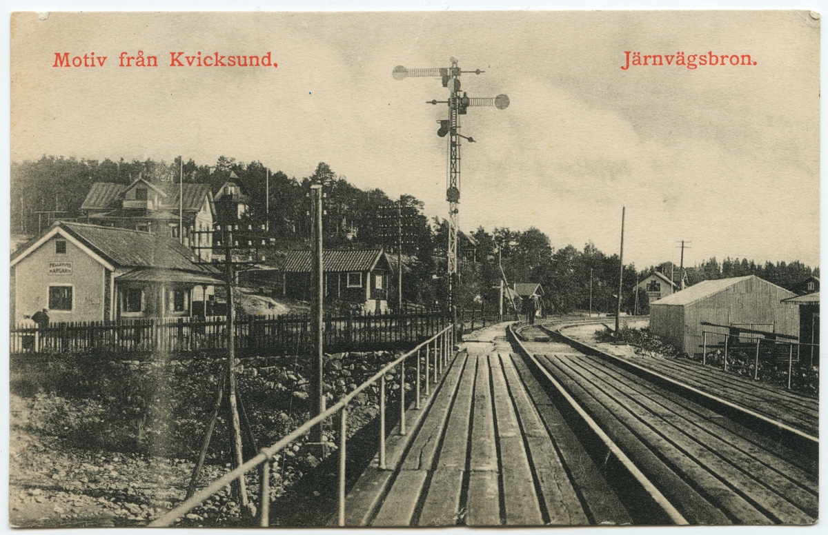Bild tagen från Kvicksundsbron mot järnvägsstationen i Kvicksund med omnejd, på linjen mellan Kvicksund och Nyckelön. Stationen skymtar längst bak i bild.