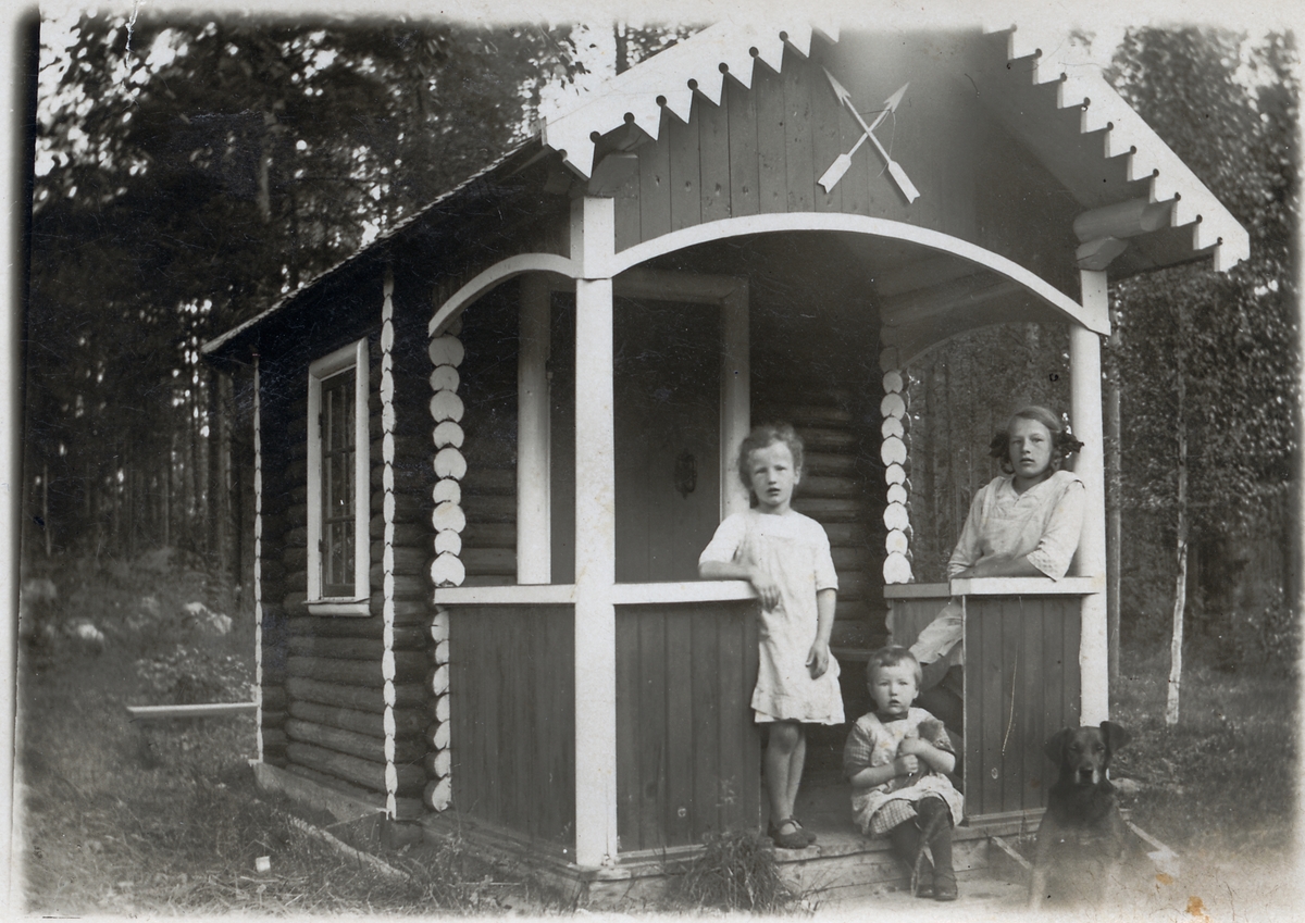 Barnen Andersson vid lekstugan i Långsjön. Från vänster Siri 5 år, Ingeborg 2 år, Astrid 14 år och familjens hund Gissa.