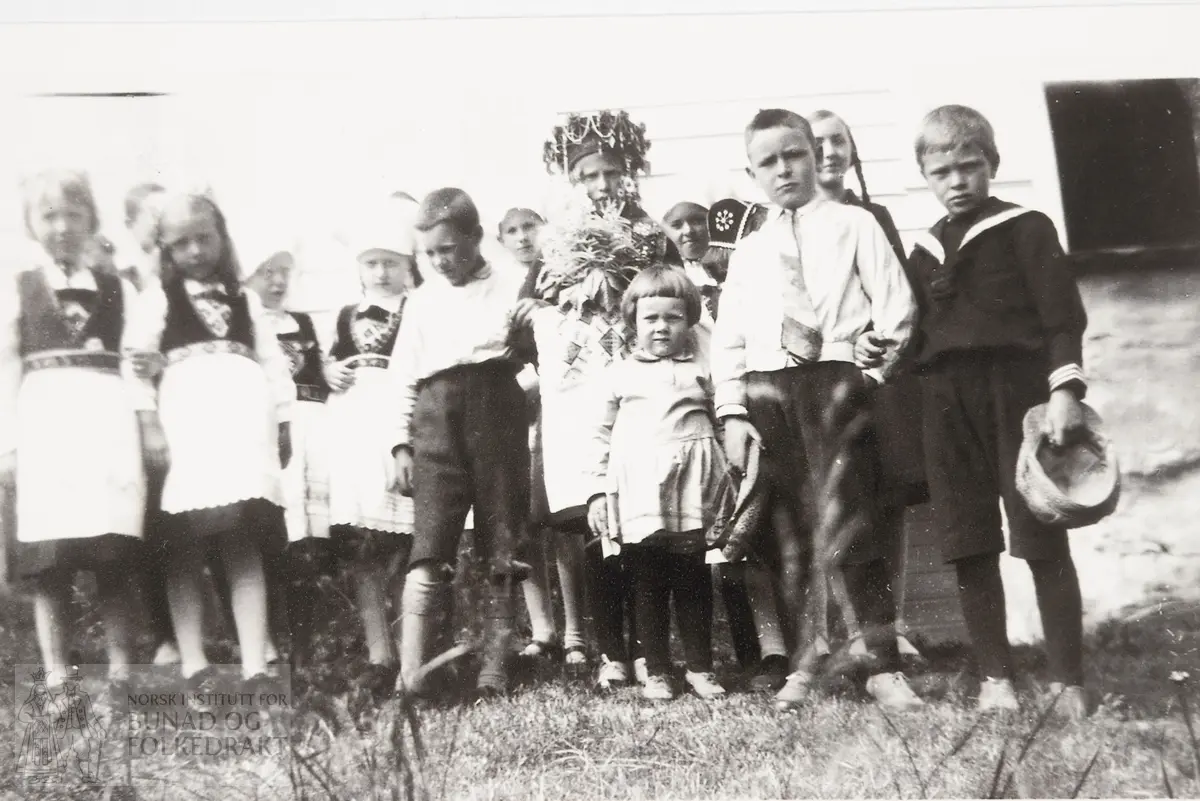 Jonsokbrudlaup i grenda Folkedal i Granvin på slutten av 1920-talet. Gruppebilete med born. Jonsokbrur med perlekrune, handaklede og blomer. Fleire skautekoner.