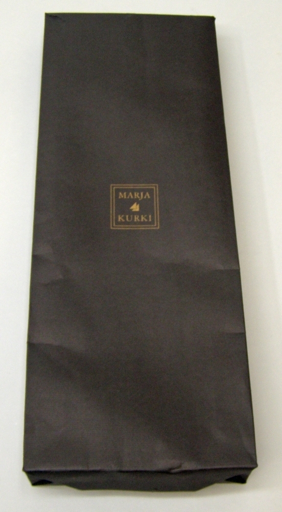 Rektangulär scarf av silke och bomull, ljusblå med långa fransar. Med Botniabanan AB:s logotyp i ett av hörnen.
I originalförpackning av papper, svart med designermärkning.