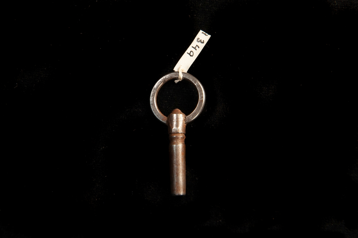 En urnyckel av järn med handtag i form av en cirkel. Något grövre nyckel.
