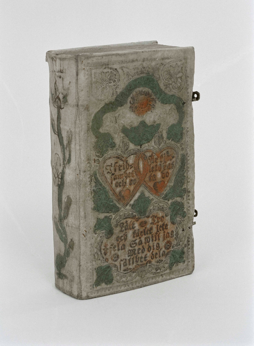 Psalmbok, brudbok, med evangeliebok och epistlar, 2 spännen.
"Den Swenska Psalmboken" i 1695 års utgåva.
Vitt skinnband med pressad och målad dekor i grönt och rött, samt text. (794 sidor)