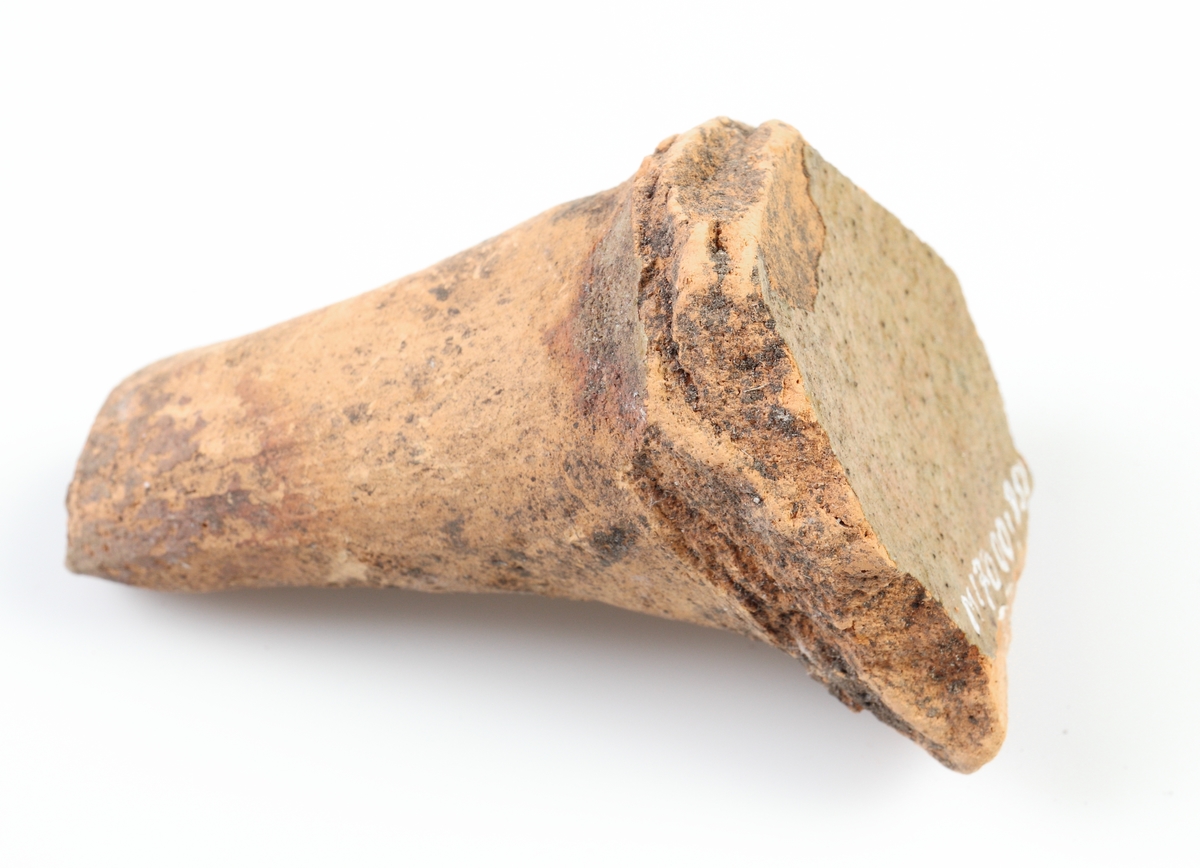 Koniskt ben i något ljusare yngre rödgods, sannolikt från en trebensgryta. Gul glasyr på kärlbukens insida. Tillverkad i södra Skandinavien.