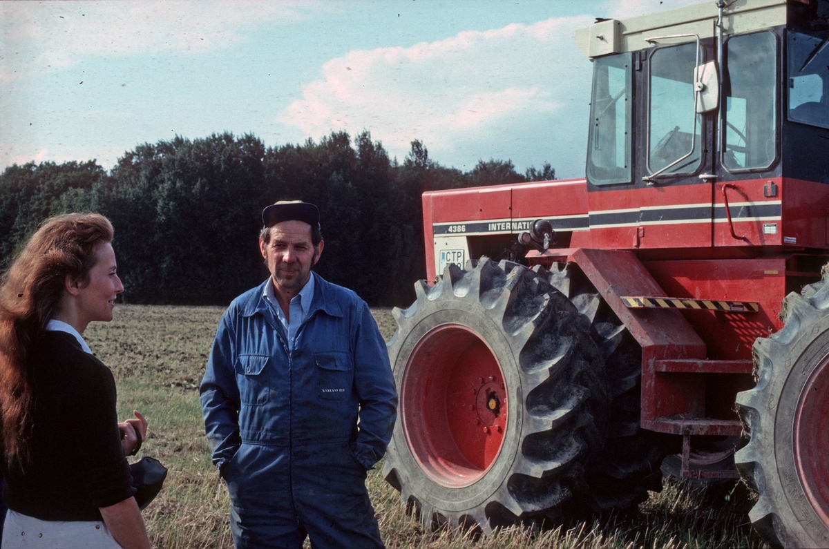 Antikvarie Iréne Flygare samtalar med traktorförare Stig Ahlin i samband med Upplandsmuseets samtidsundersökning av Hacksta gård, Enköpings-Näs socken, Uppland 1981 -1982