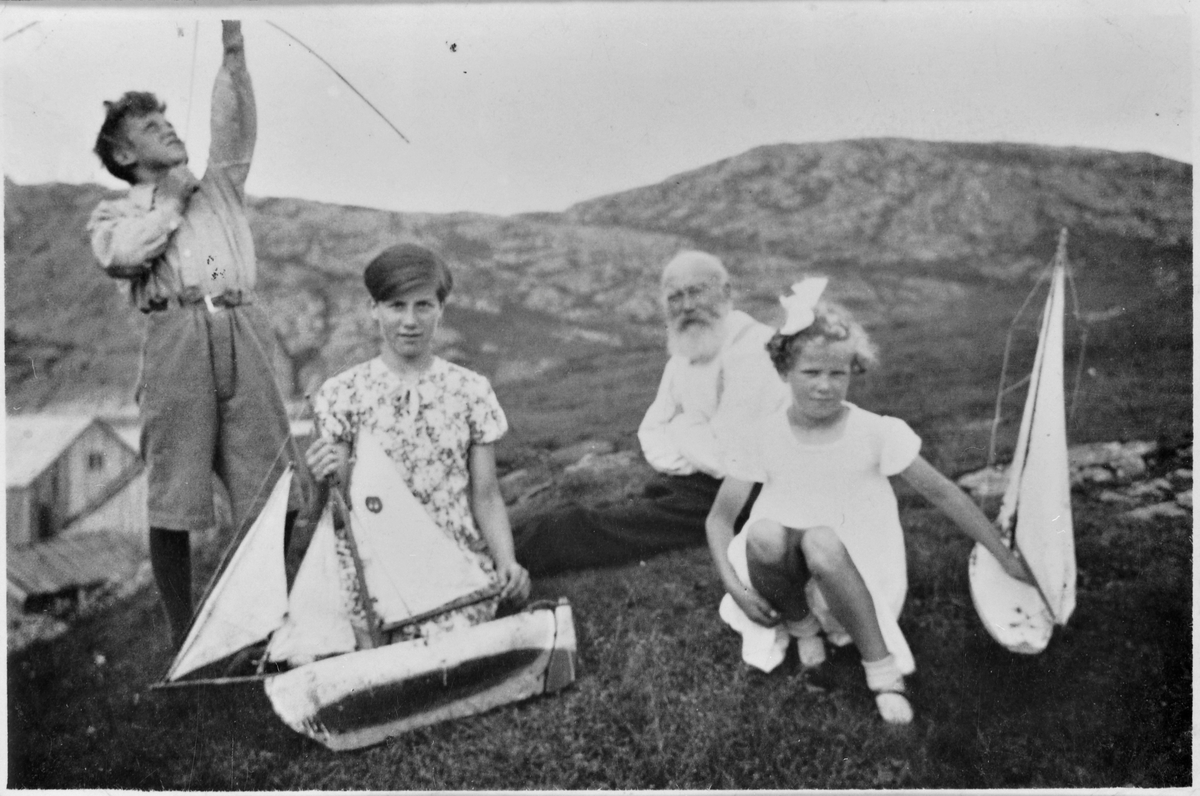 Barn som leker med båter og pil og bue, bestefar sitter bak, Bjugnholmen, Bjugn.