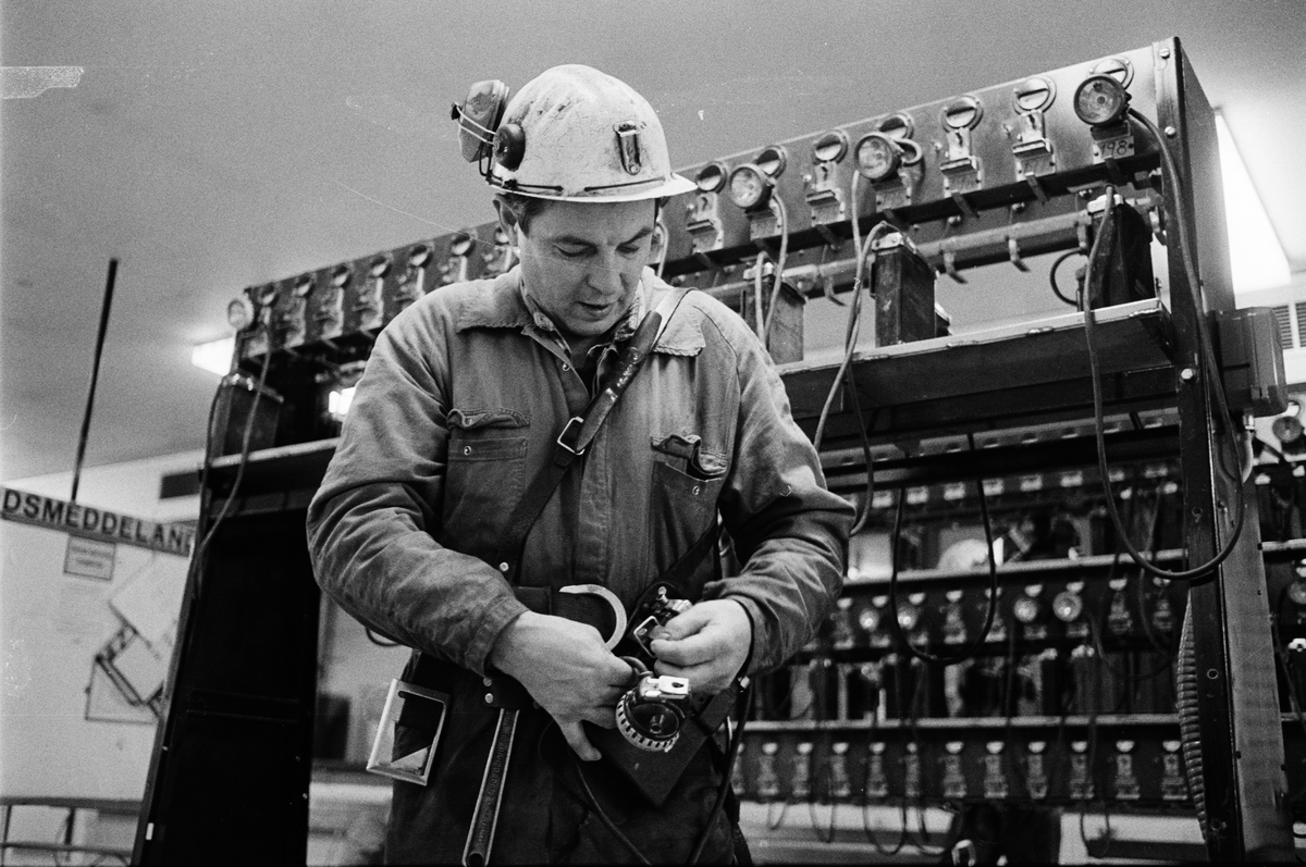 Reparatör Stig Lind tar på sig batteriselen, gruvstugan, Dannemora Gruvor AB, Dannemora, Uppland oktober 1991