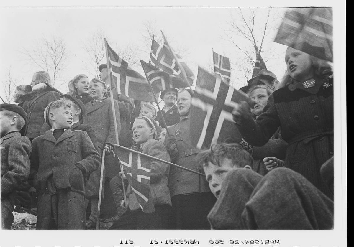 Tusenvis av folk har møtt fram for å ønske de norske polititroppene velkommen til Narvik. Barn med flagg.
