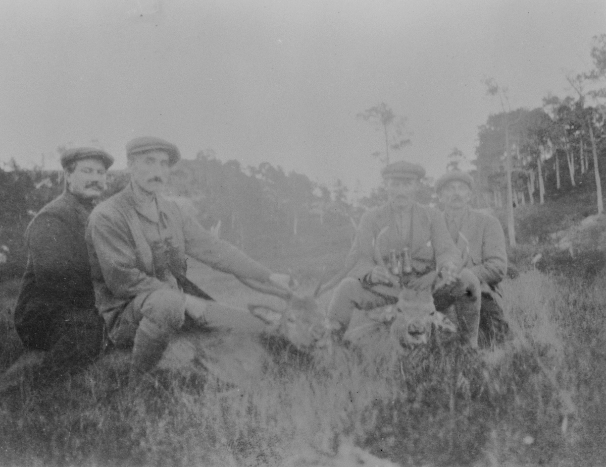 Gruppebilde, 4 menn viser fram 2 hjort etter jakt.