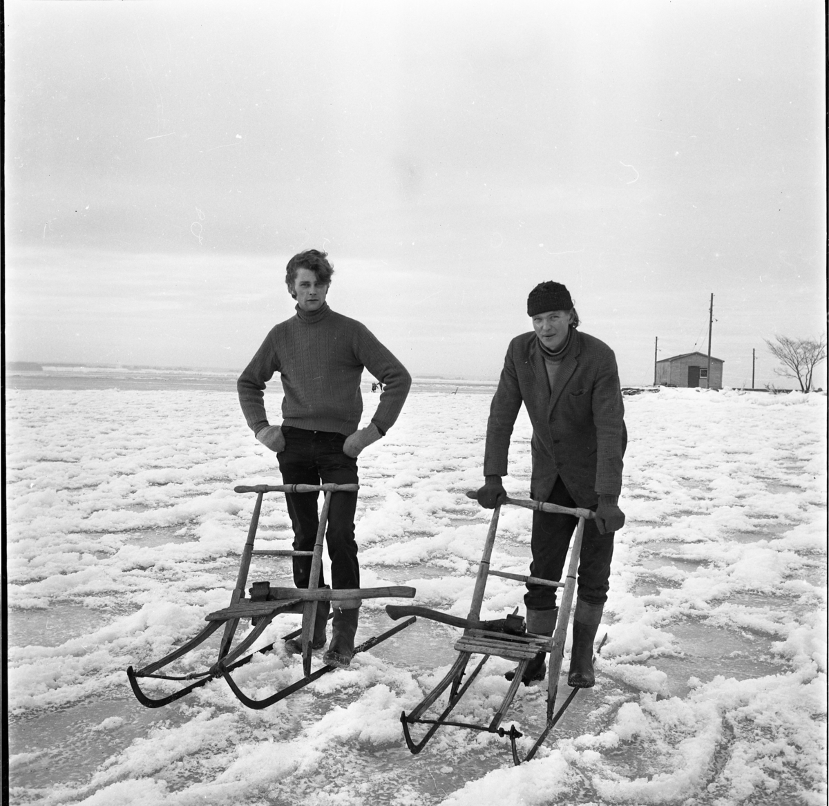 Två ungdomar, bröderna Karl-Gustav och Björn Frisk, med sparkstöttning på Vätterns is vid Gränna hamn.