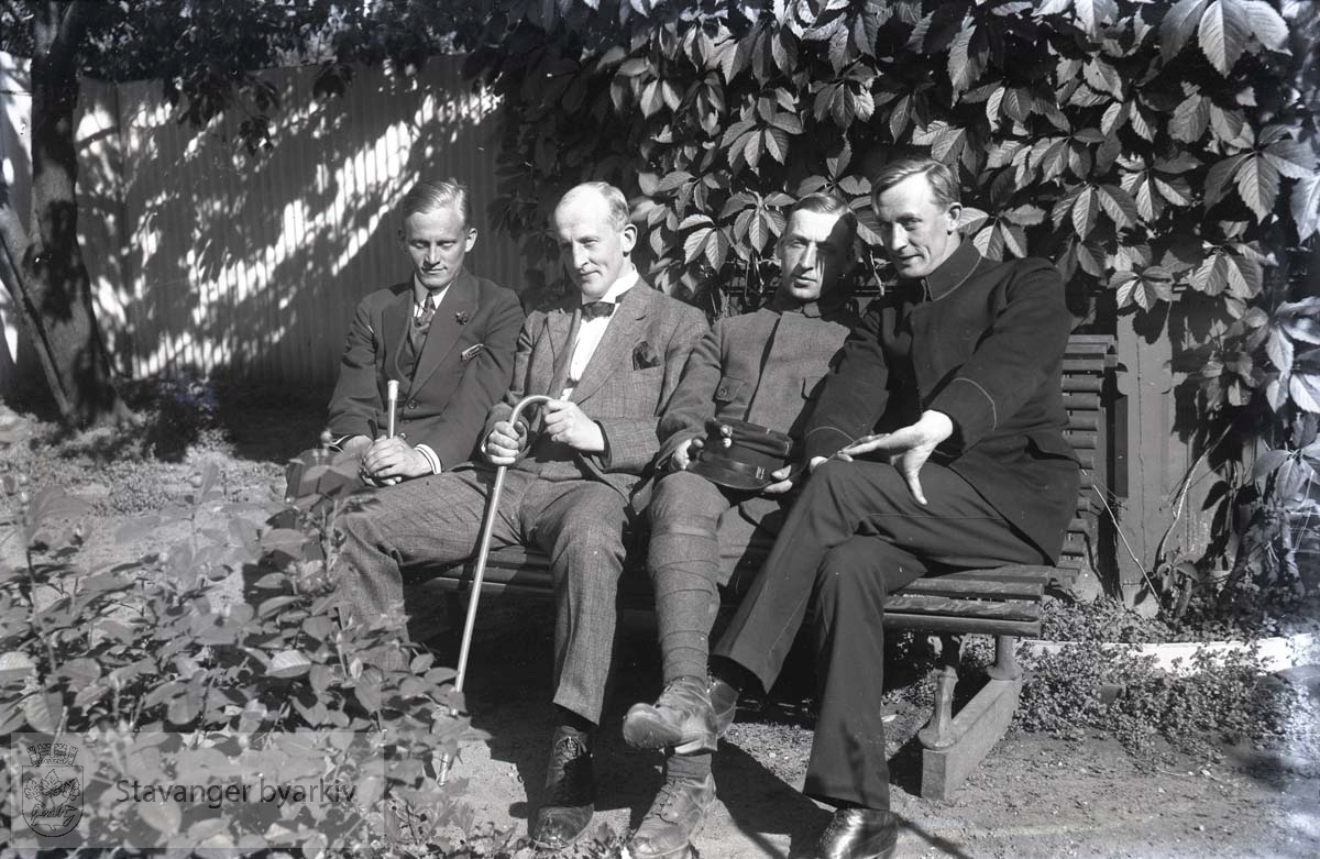 Fire menn på benk i park eller hage