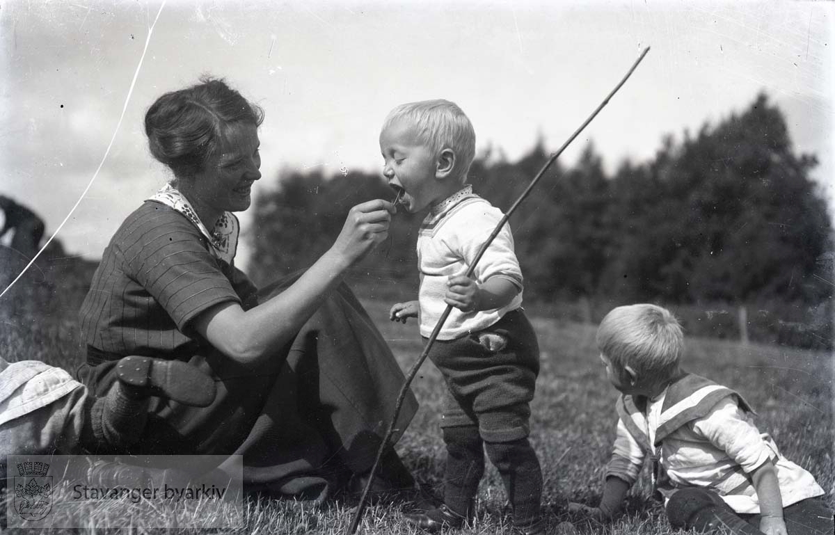 Kvinne og to barn i gresset