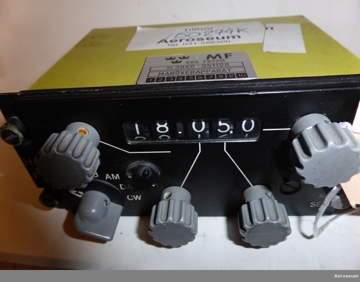 En manöverapparat. Den har en svart front med vridbarara knappar och rattar. Skalet runt om är gult. Den är tillverkad av Collins Radio Company.

På föremålet står det på ena sidan: "[tre kronor] MF CVA 7803Ö", "M3955-051128", och "MANÖVERAPPARAT". På botten går det att läsa: "CONTROL", "TYPE 714E-3", "FAA-TSO-C31b [utsuddat] C32b CAT. B", "WT. 2.0. LBS", "SER. NO. 655", "COLLINS PART NO.", "522-2457 00", "COLLINS RADIO COMPANY CEDAR RAPIDS, IOWA, U.S.A.", och "MCN 834".