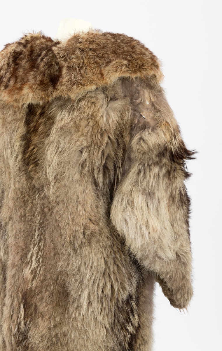 Kjørepelsen har ukjent opprinnelse. Merket med "Alf Risberg" er påsydd på jakketforet. Det er ellers et brunt jakkefor. Foret har brun bunnfarge og tynne hvite og grå striper, som danner et rutemønster. Pelsen har fire skinnknapper, og fire skinnhemper til å feste knappene i. Det er også en krage på pelsen.