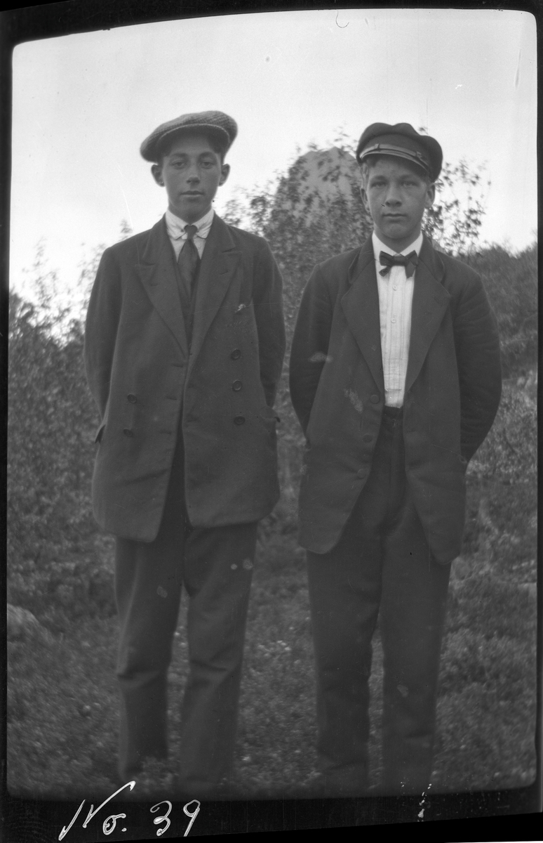 Portrett av to unge menn stående utendørs.