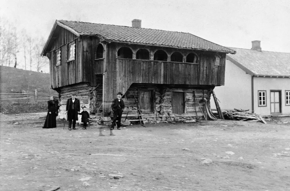 Svart-vhitt foto av høyloftet på Skråstad gard med noen mennesker rundt.