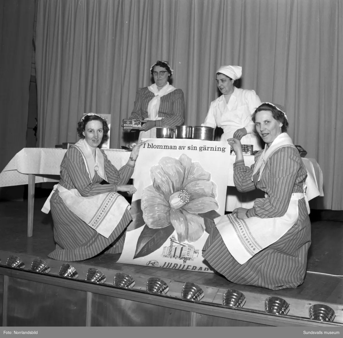 Fyra kvinnor på matlagningskurs för husmödrar.