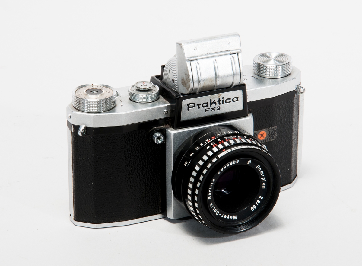 Spegelreflexkamera för småbildsformatet.Praktica FX3, Ljusschaktsökare med lupp, tillhörande prismasökare medföljer.
Objektiv: Meyer-Optik Görlitz typ Domiplan 2,8/50 nr 2998806.