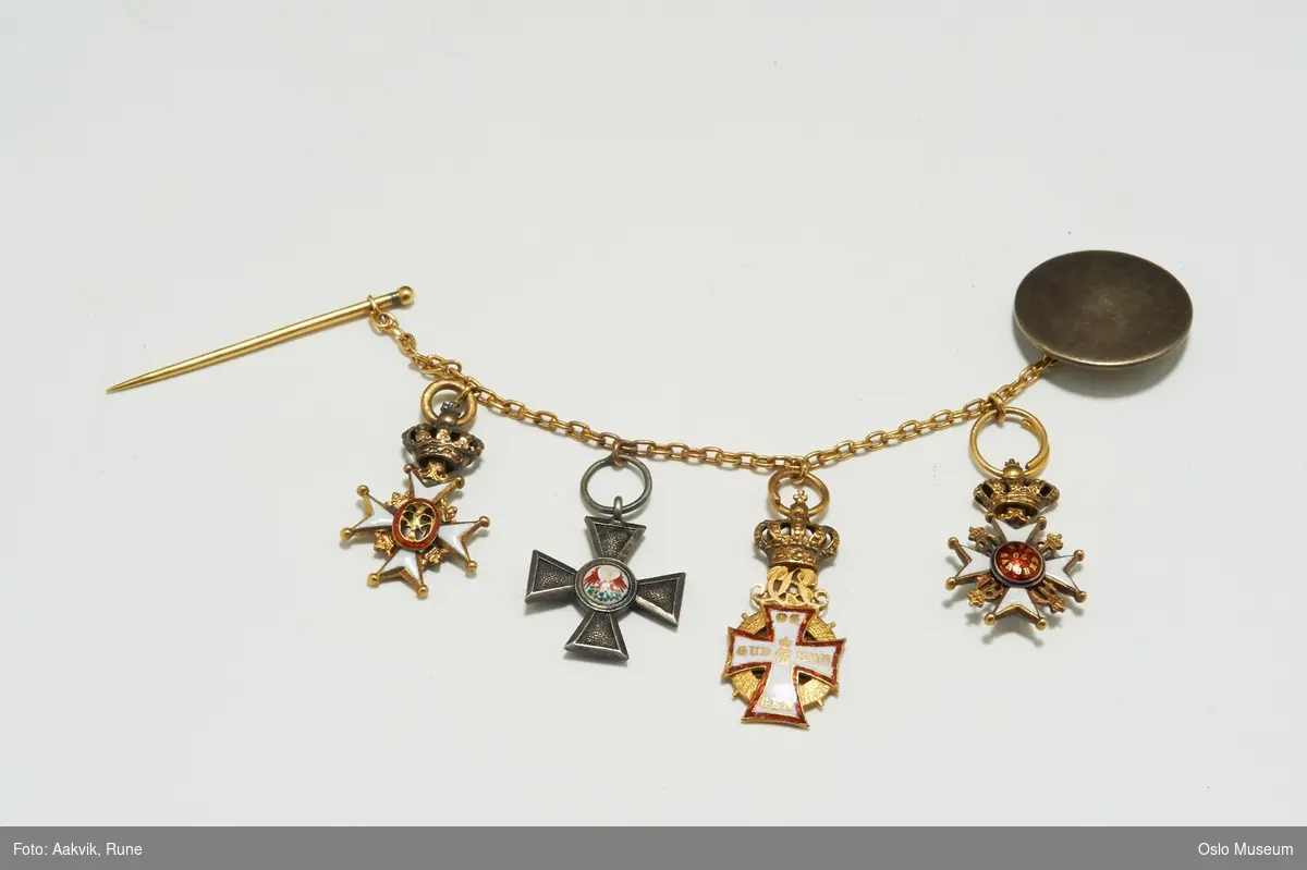 4 miniatyrer i lenge med nål (festemekanisme) og "knapp". Blant annet St. Olavs orden og Nordstjernen.
