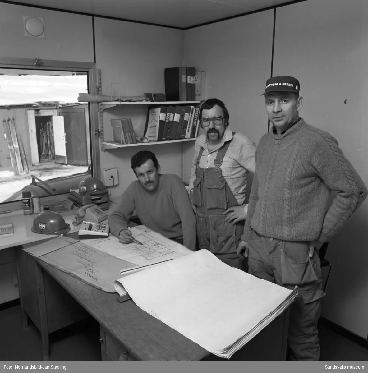 Byggkontor i Granloholm, tre män planerar arbetet.