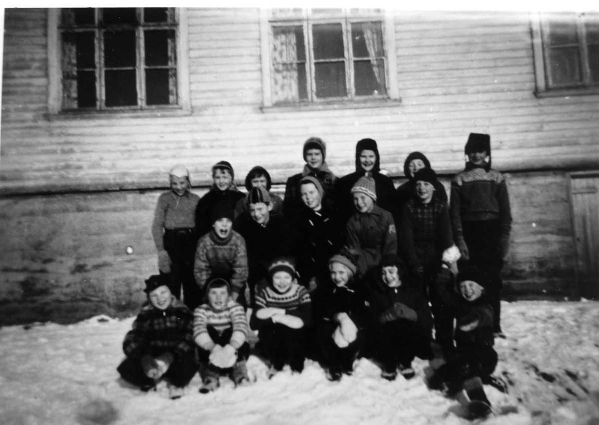 18 skoleelever samlet foran gammelskolen på Å i Tranøy.1957-58. - Midt ...