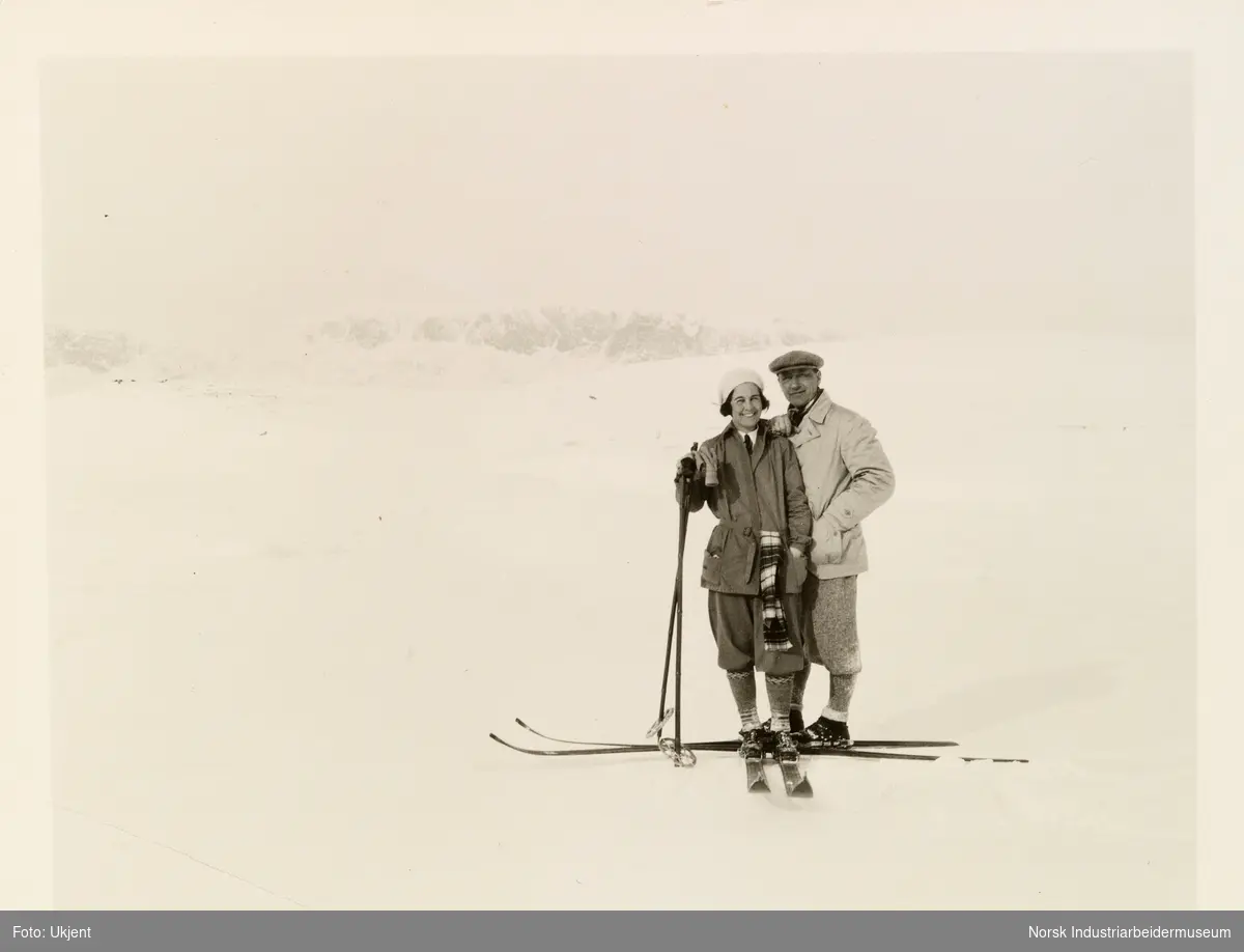 Mann og kvinne på skitur i turantrekk, med ski og skistaver