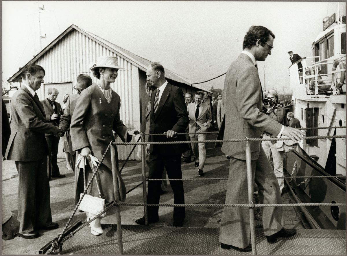 Kung Carl den XVl Gustaf och Drottning Silvia kliver ombord på Trafikaktiebolaget Grängesberg - Oxelösunds Järnvägar, TGOJ:s bogserbåt "Simson", som ligger förtöjd vid kajen i Oxelösunds hamn den 9 september 1980. Tilll vänster i bild kan Magnus Värmon ses.