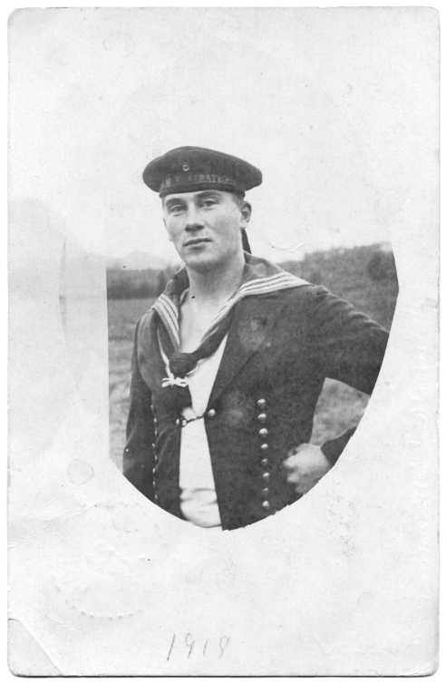 Vitt kort med en oval med porträtt av ung man i flottans uniform. På hans mössa finns texten: "H.M.S Albatross"