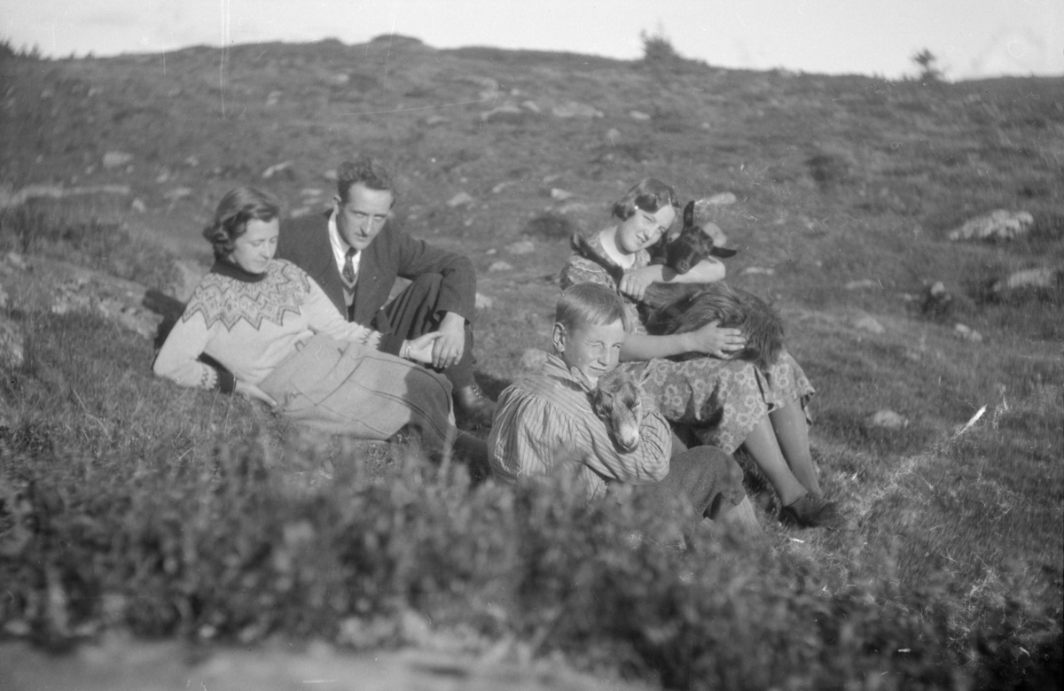 To voksne og to barn, barna med geiter, antageligvis på Skei, Gausdal.