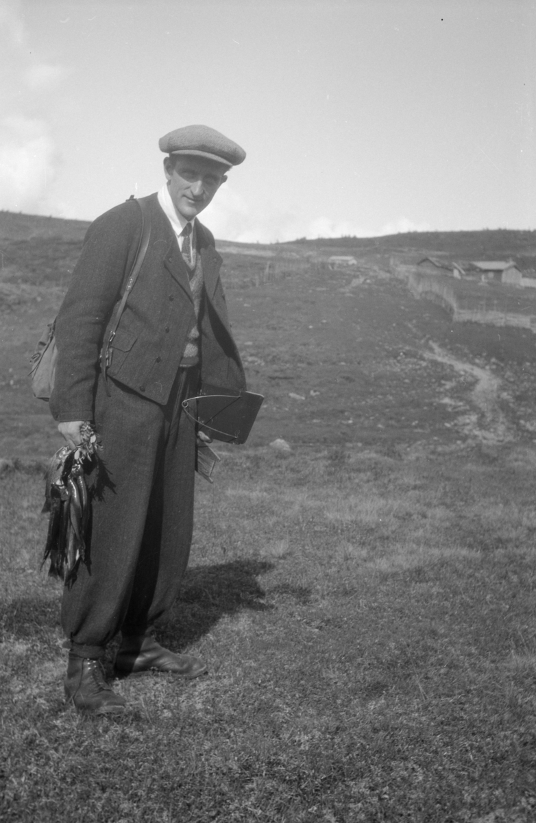 Mann med et knippe fjellaure og ei oterfjøl, antageligvis Skei, Gausdal