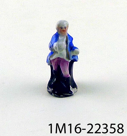 Handmålad figurin av porslin föreställande en adelsman, stående.