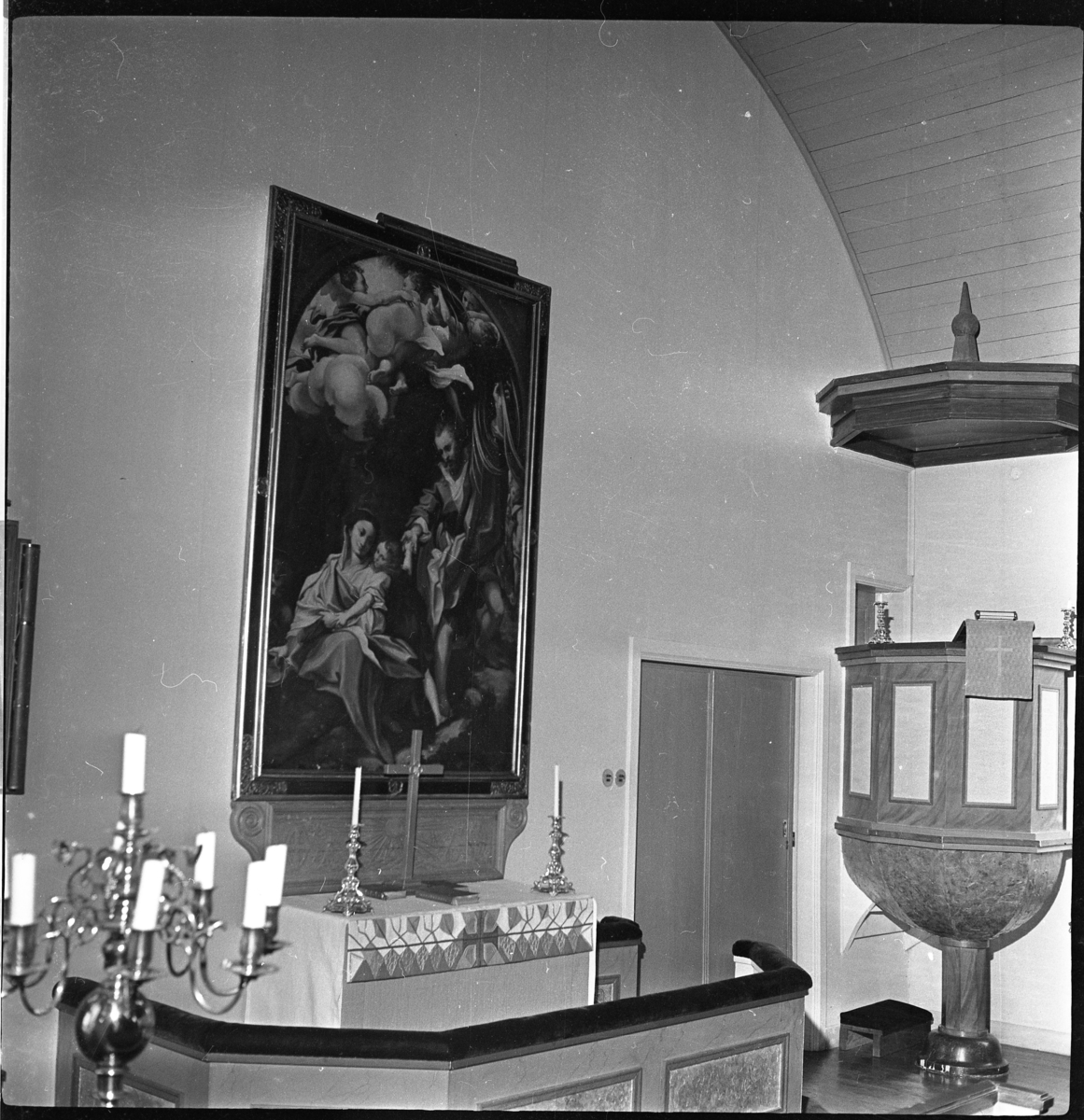 Koret med altartavla i Örserums kyrka. Altartavlan "vilar på" ett snidat träunderstycke tillverkat av snickaren och bildhuggaren Axel Johansson.