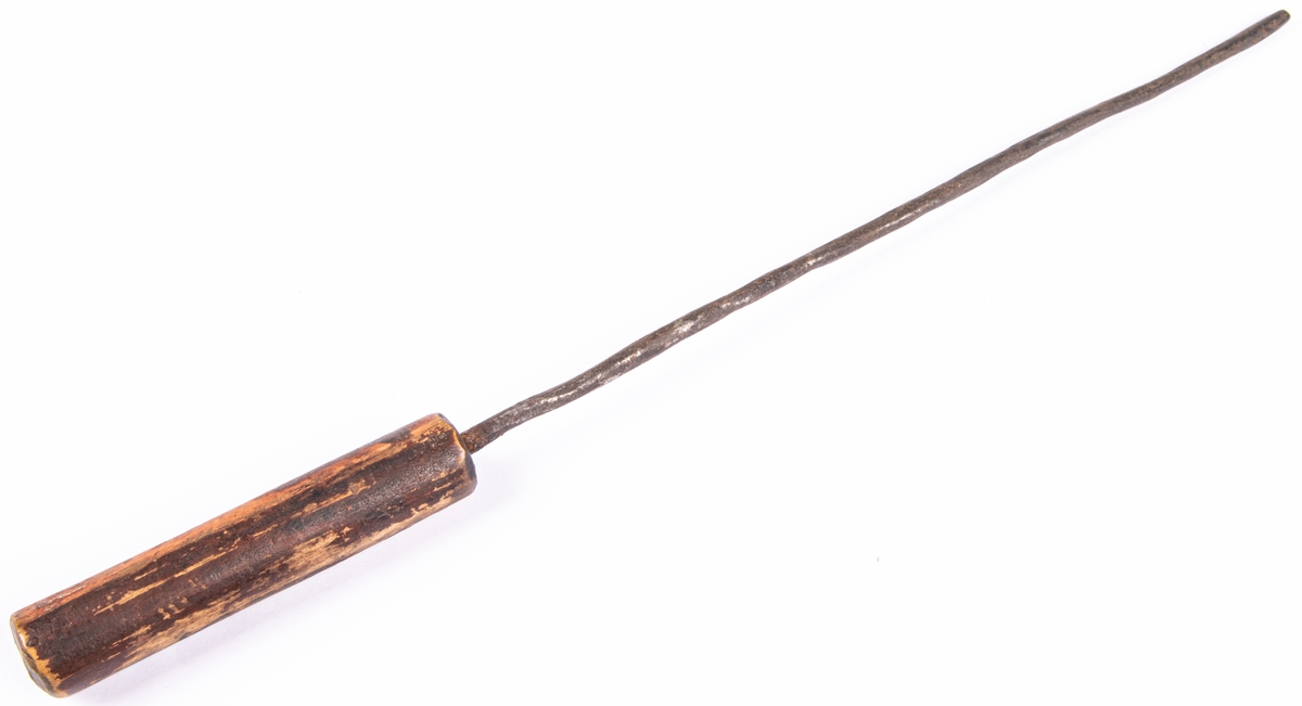 Stekspett, rakt, av järn, liknar grov ståltråd, fäst i rundsvarvat träskaft. Längd 36,2 cm.
