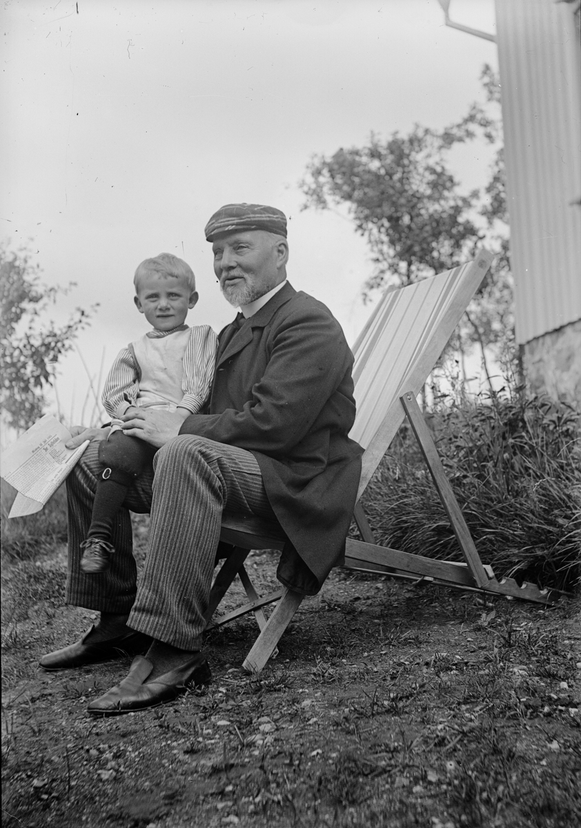 Christiane Liljefors far Roland Pedersen, med sitt barnbarn Roland Liljefors, sitter ute i trädgård, sannolikt i Norge
