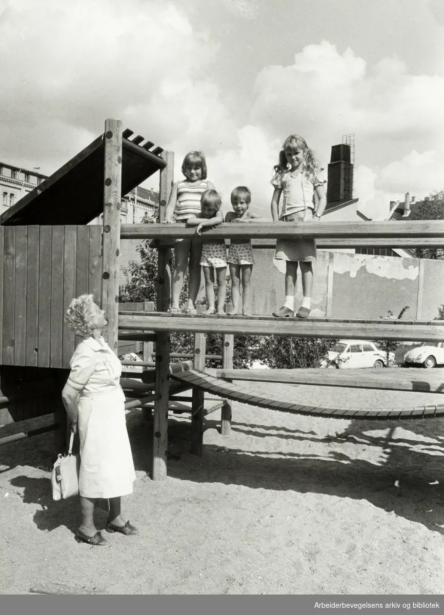 Klosterenga har fått lekeapparater. Ingeborg Teie Leirvik besøker barnebarna Marian og Kristin (i Midten), Ann-Kristin og Evy måtte også prøve lekeapparatet. August 1980