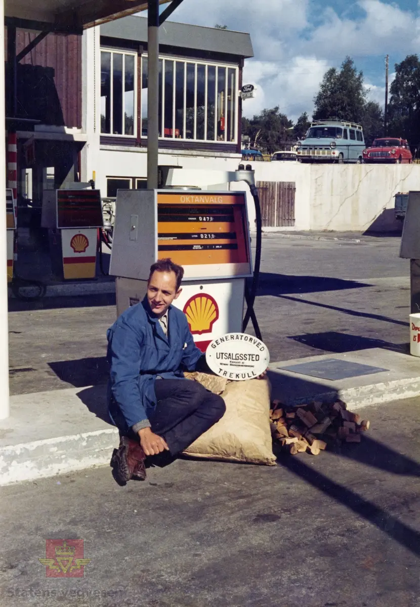 Bildet er tatt på Dombås Shell stasjon under oljekrisen i 1973-1974. 
Ved bensinpumpa sitter Kjell Storrusten. 
I bakgrunnen står en blå Ford Transit produsert mellom 1965-1971, og en rød Ford Taunus 12m Kombi fra midten av 1960-tallet.