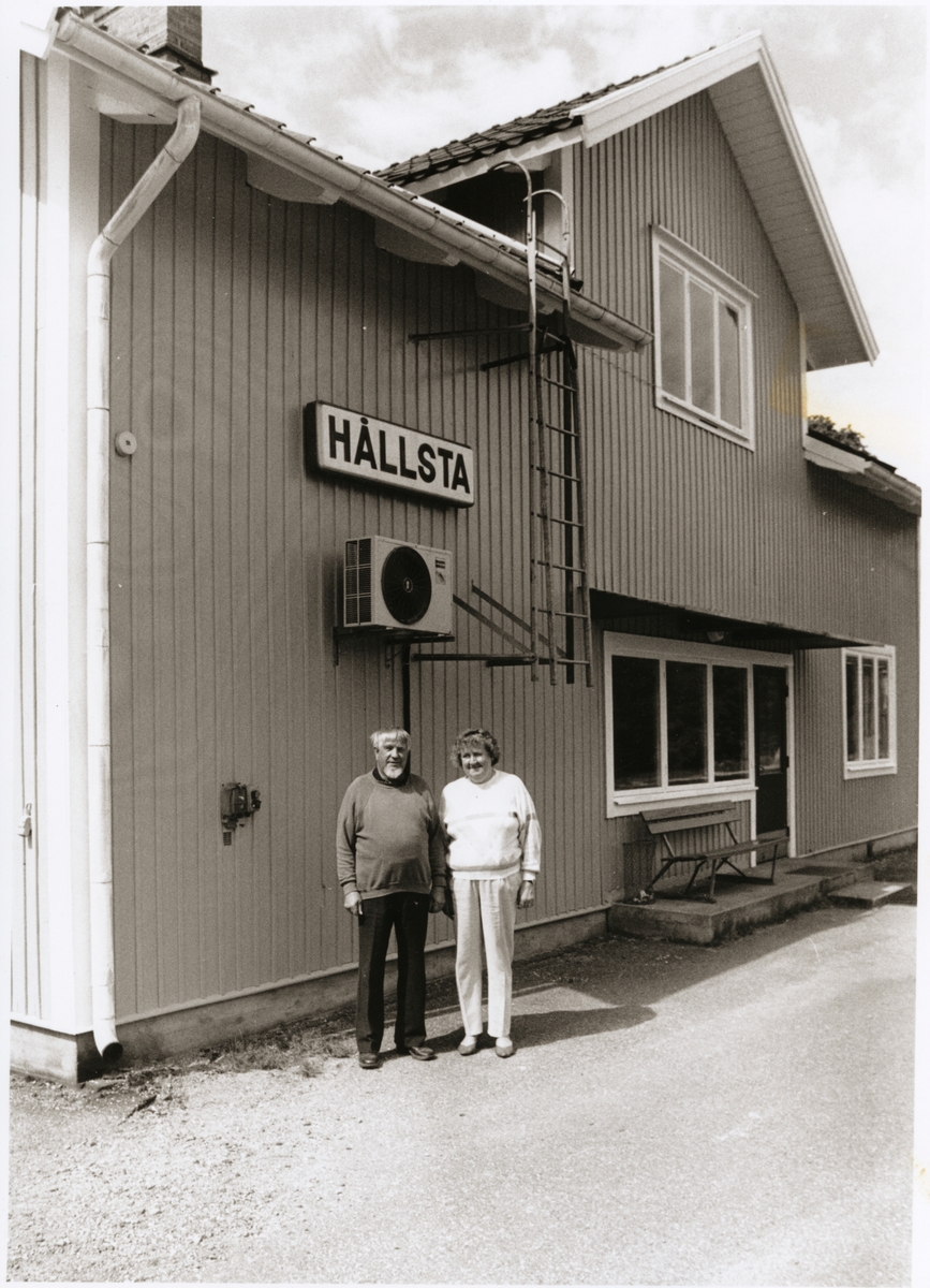 Tage Lundvall pensionerade från Trafikaktiebolaget Grängesberg - Oxelösunds Järnvägar, TGOJ med sin fru Maj-Britt utanför stationshuset i Hållsta som har varit hans arbetsplats och sedan deras hem.