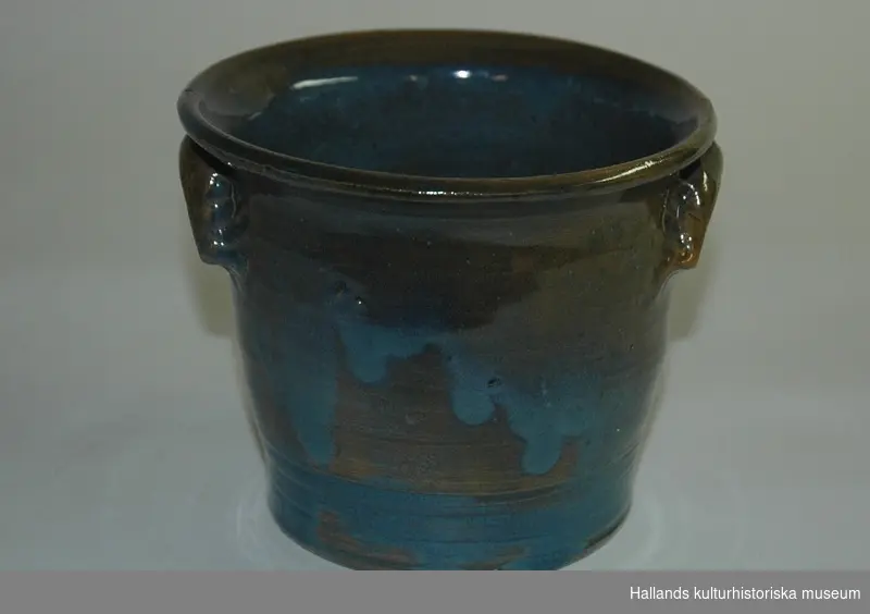 Kruka av bränd keramik. Brun och blåmelerad, glaserad, med utböjd kant. Märkt i botten: "Bror Cederholm, Varberg."