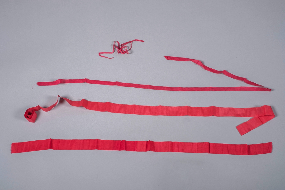 Originale bånd til dåpskjole. 5 røde bånd i diverse størrelser, 2 brede, 1 mellombred og to smale.