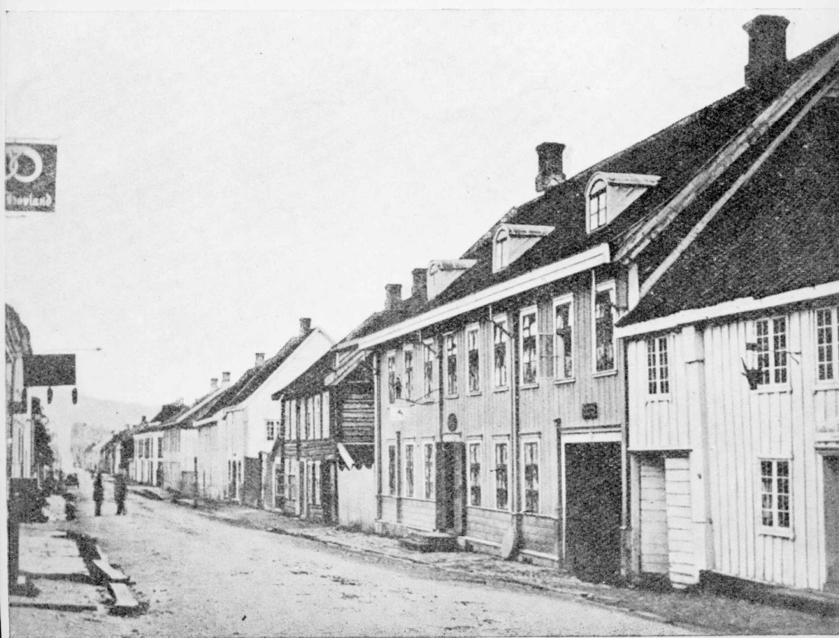 Repro: Gatebilde fra Storgata, Lillehammer. Den store bygningen er nr. 72, mens huset i bildekanten ble revet da Wieses gate ble anlagt.