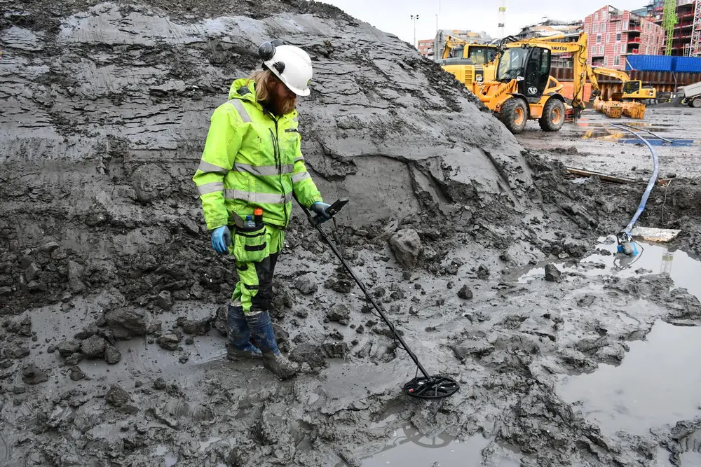 Arkeolog Lars Bigum Kvernberg med metalldetektor nede i sjøbunnsleira på B8a