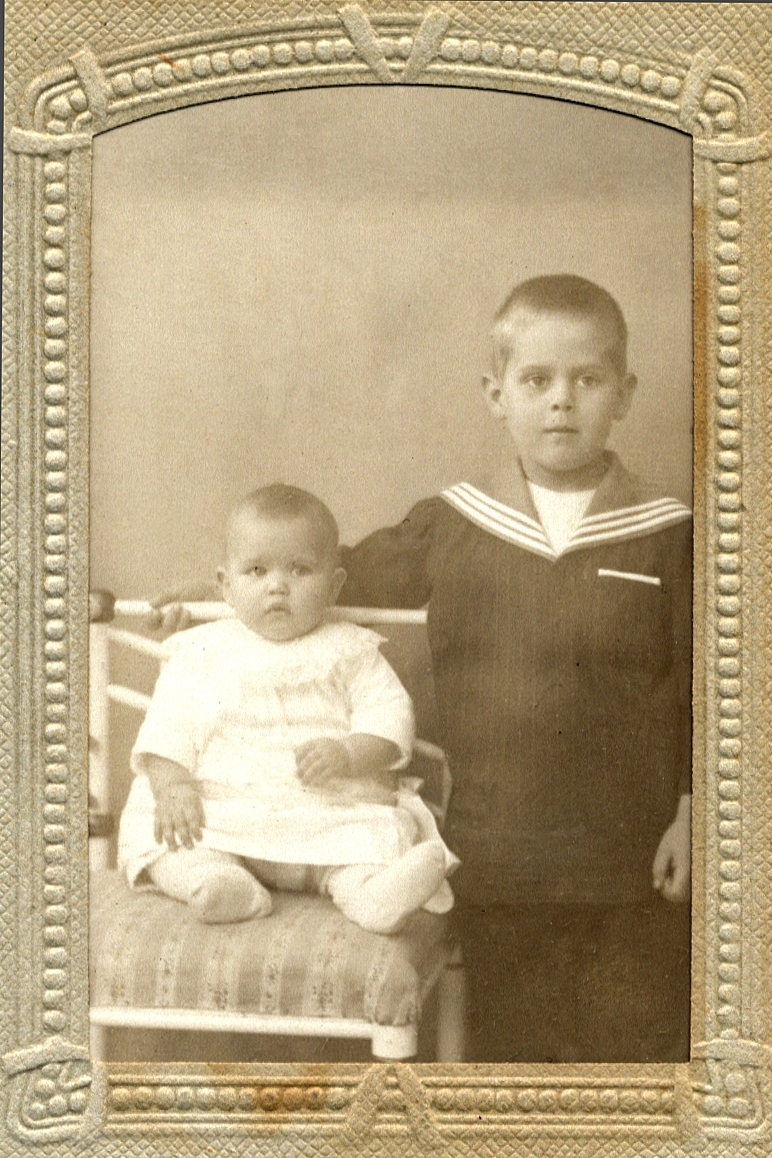 Gruppfoto av två barn. en pojke och en baby, klädda i sjömanskostym och kolt. 
En face. Ateljéfoto.