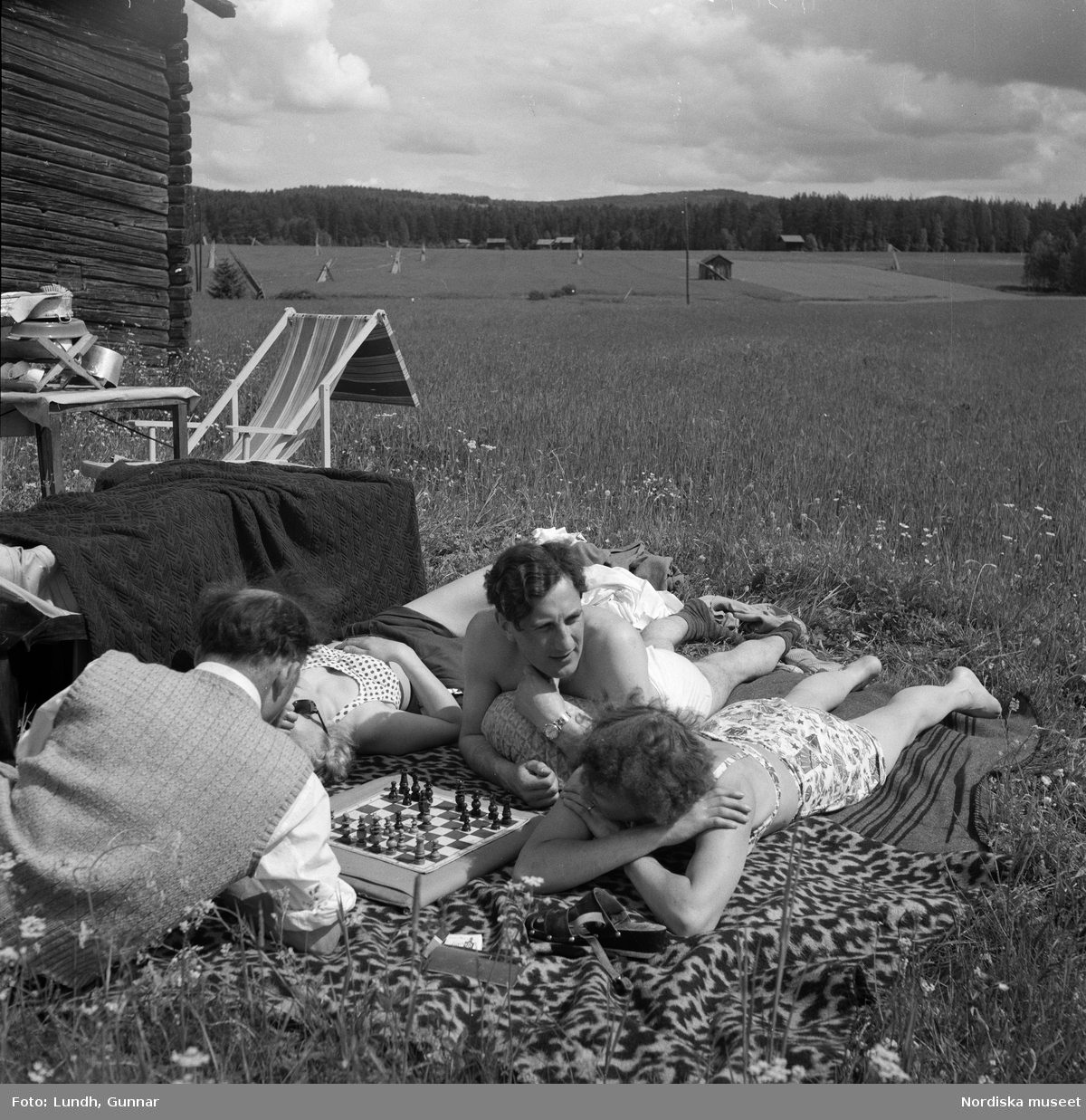 Motiv: (ingen anteckning) ;
Porträtt av en man författaren Frans G Bengtsson, en gärsgård, två kvinnor och två män ligger på marken och spelar schack vid en parkerad bil med husvagn, en kvinna står vid dörren till en husvagn, porträtt av en flicka som håller blommor.