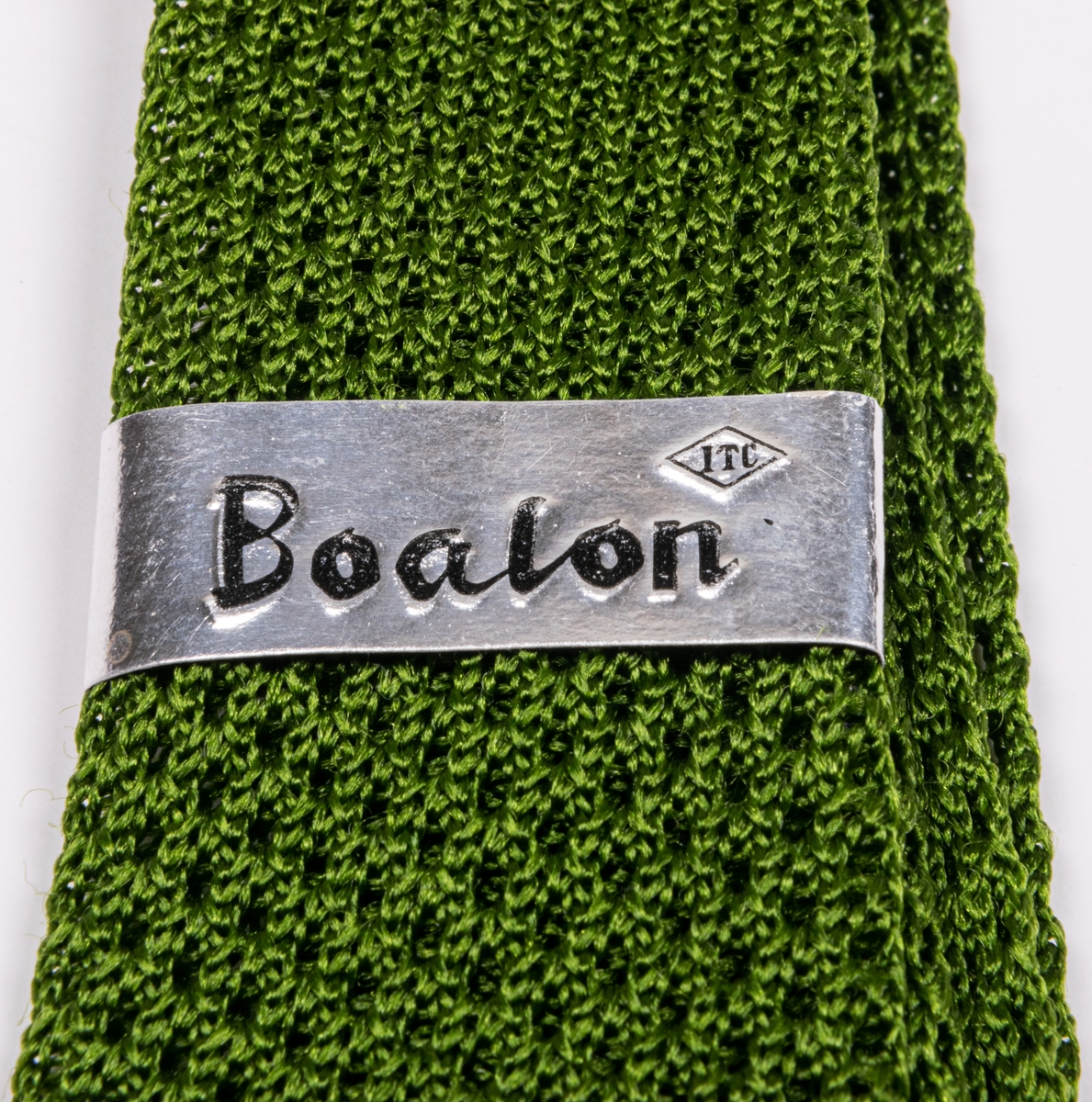 Nylonslips av grön trikåväv. Nedtill en etikett med text: Boalon Nylon made in Japan.