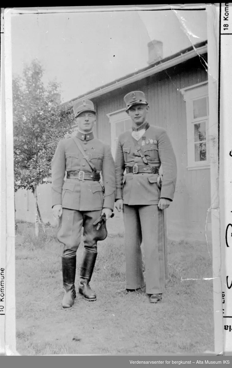 2 offiserer på Altagård. På bildet ser vi to menn i uniform som står foran en militærbygning.