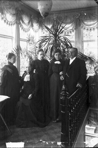 Gruppbild med fyra kvinnor och en man, som är baron von Rosen. De står i trapphuset till Brahegatan 20. Närmast baron står möjligen hans hustru och de andra kvinnorna är hans syskon e motsv.
