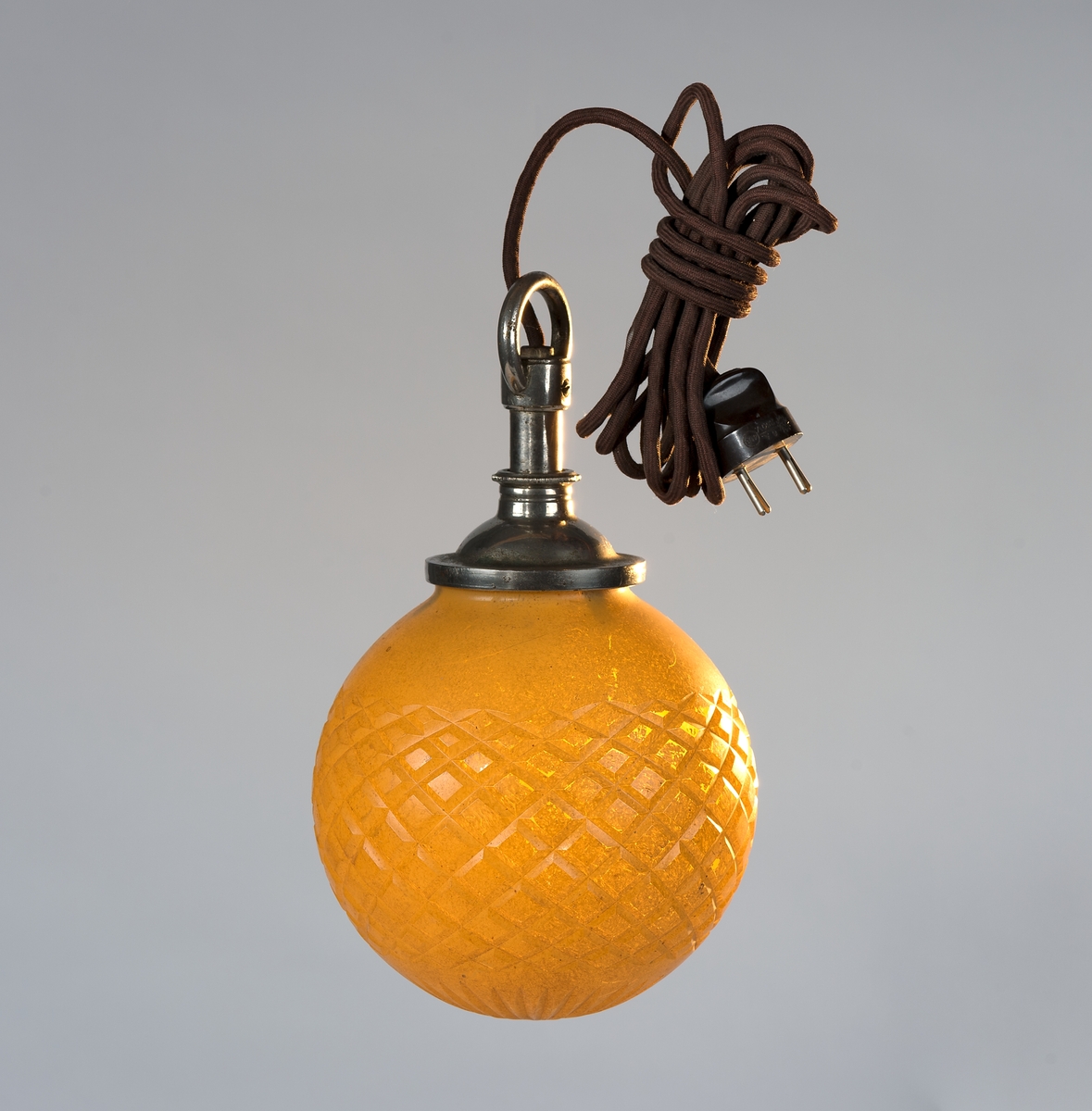 Klotformad gul lampa med stickkontakt.