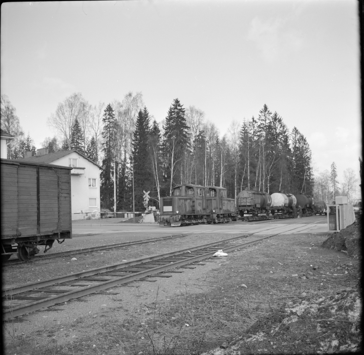 Hällefors - Fredriksbergs Järnvägar, HFJ multipelkopplade lokomotorer 4 och 3 med godsvagn tank vid järnvägsövergång i Hällefors.
