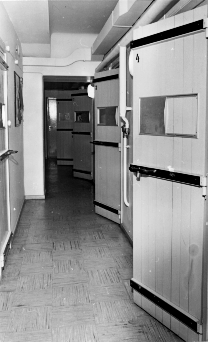 Kasernvakten, omkring 1980

Arresterna låg vid kasernvakten i kasern 004 från slutet av 50-talet och ca 30 år framåt. Användningen under de senare decenierna var nog mycket litet.

Bild 1: De fyra arresterna ser vi här på höger sida av gången, de hade ett litet fönster för ljusinsläpp och vädring. Dörren på v sida är till "fyllarresten" -- ett kalt rum med ett uppbyggt sluttande trägolv, en golvbrunn och en vattenslang. Okänt hur många som kunde sova ruset av sig samtidigt.

Bild 2: Vanlig arrest. Sängen låstes i uppfält läge dagtid. En rostfri toalett och handfat fanns också. OBS! bilden är arrangerad och personen var nog bara fotomodell.