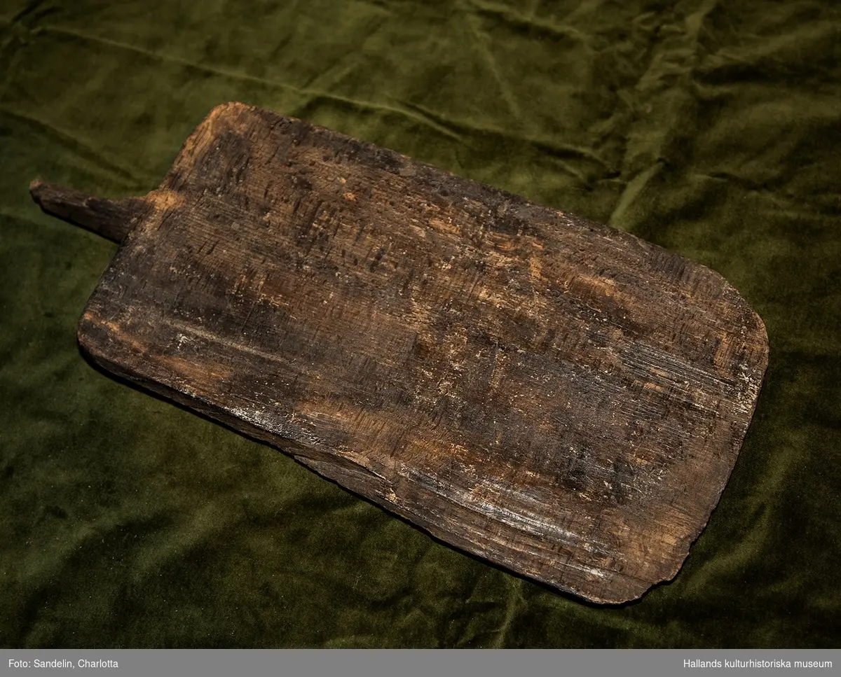 Arkeologiskt föremål. Del av spade av trä. Bredd 22 cm. Höjd 37,5 cm. Skaft 8,5 cm. Rektangulärt blad, tjockare i bakänden. Avbrutet skaft. 