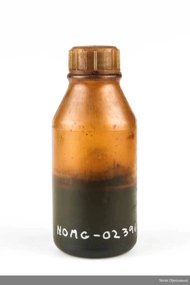 Oljeprøve fra første produksjon på Statfjord A. Plastflaske med oljeinnhold.  Flasken har innstøpt logoen til Mobil.
